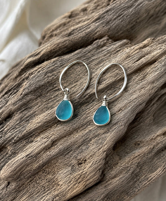 Aqua sea glass earrings on driftwood