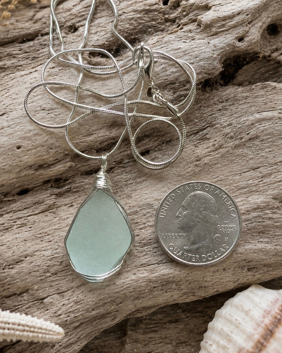 Seafoam aqua sea glass pendant wire wrapped in sterling silver, quarter size, on driftwood