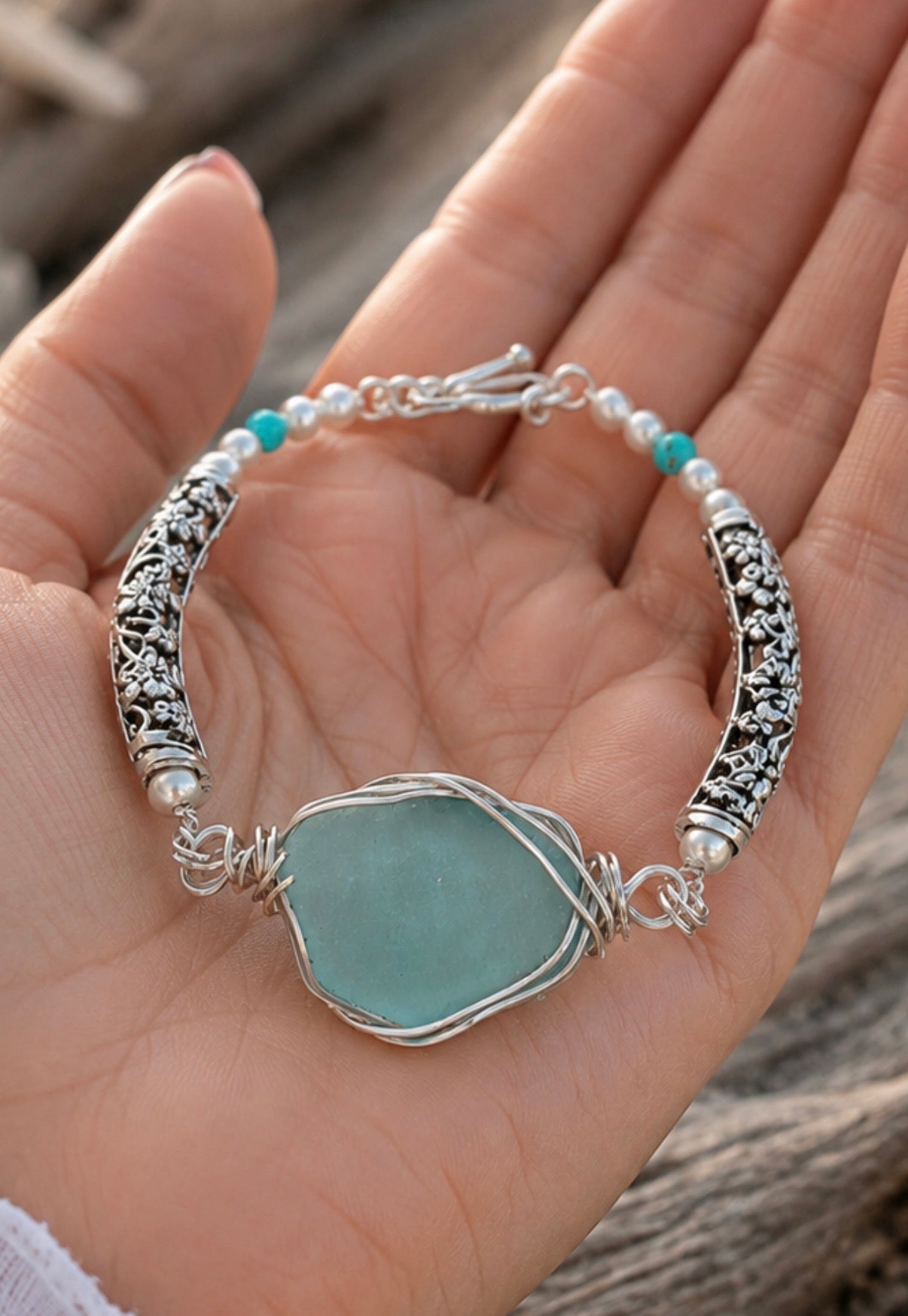 Aqua sea glass bracelet held in hand