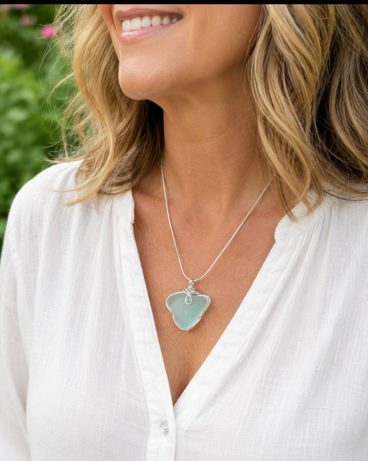 Natural heart sea glass pendant worn on model