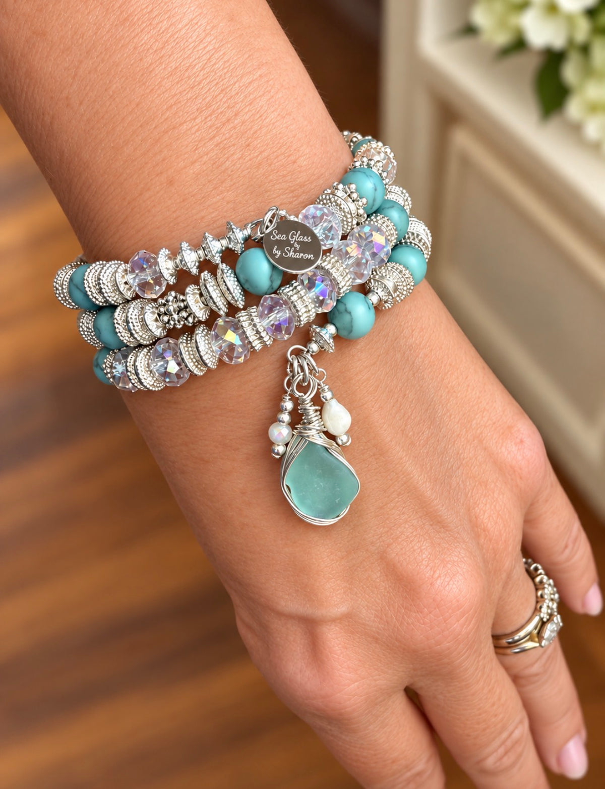 The Spiral aqua sea glass wrap bracelet worn on a wrist