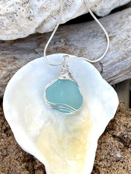 blue cord sea glass necklace hanging on manakin neck